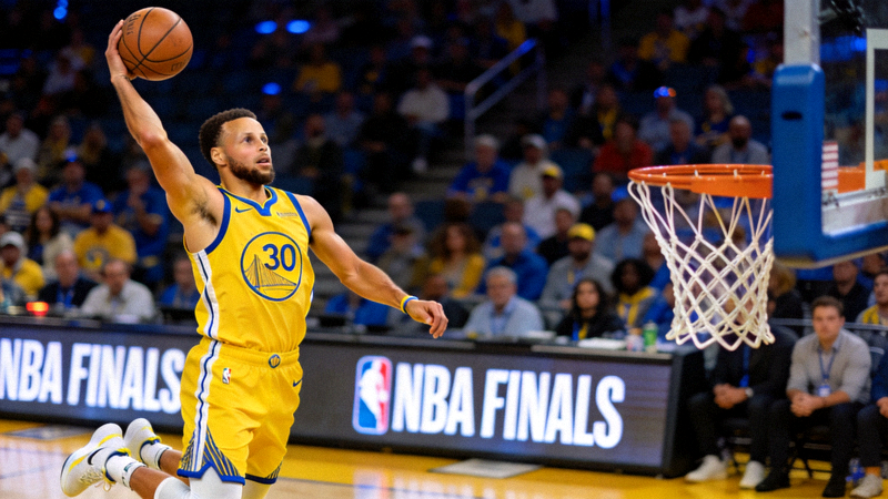 NBA总决赛勇士队球员斯蒂芬·库里投出关键三分球 - 篮球场上库里投篮的专注瞬间